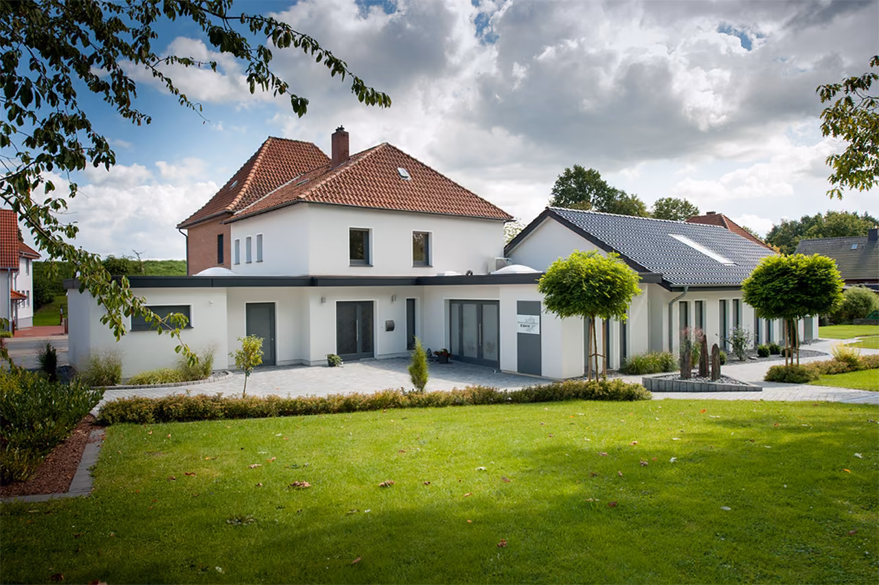 Bestattungshaus Melle-Buer: weiße Villa mit Anbau und Rasen
