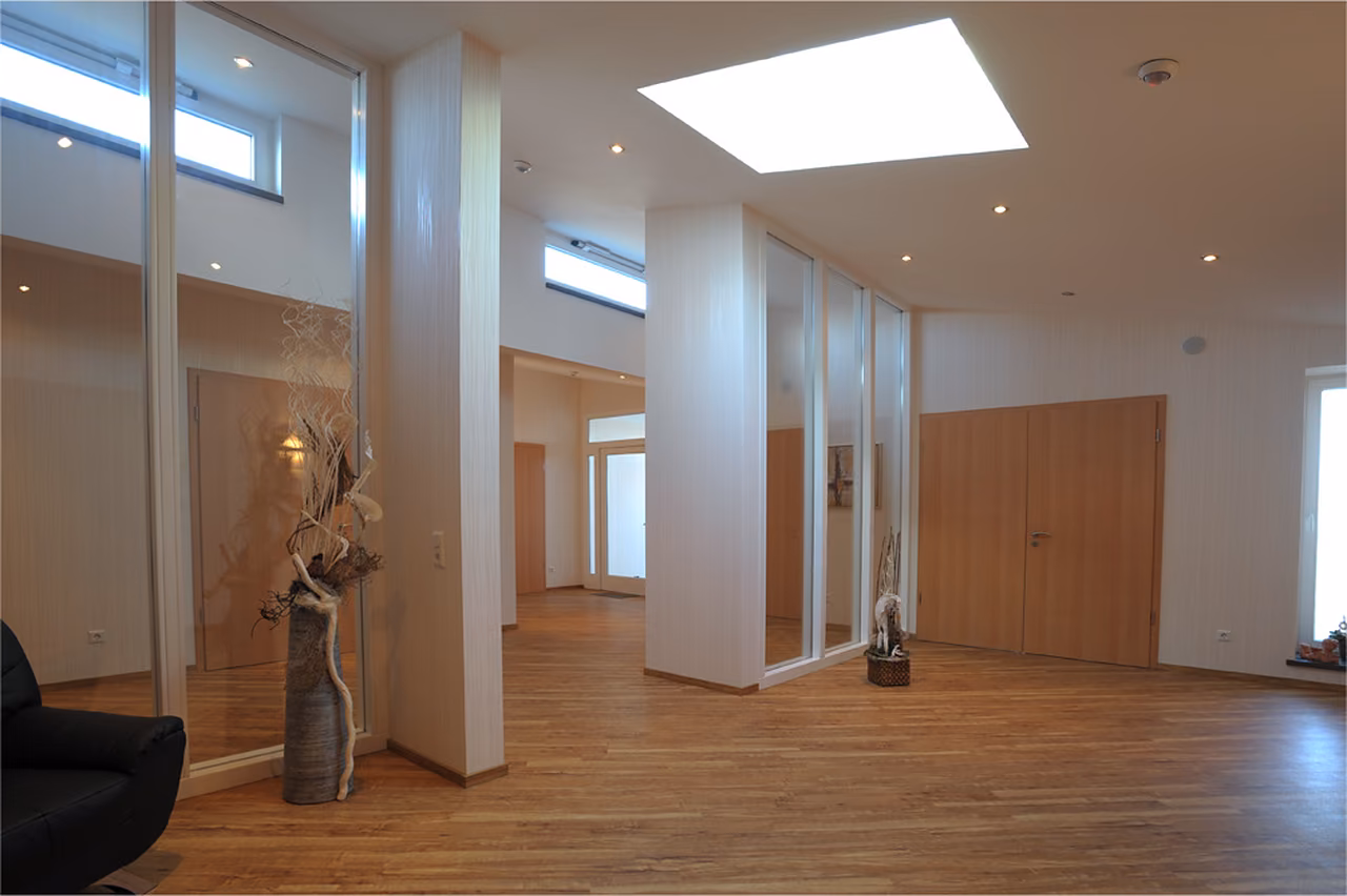 Helles Foyer im Bestattungshaus Rödinghausen mit Holzboden, Oberlicht und Glaswänden